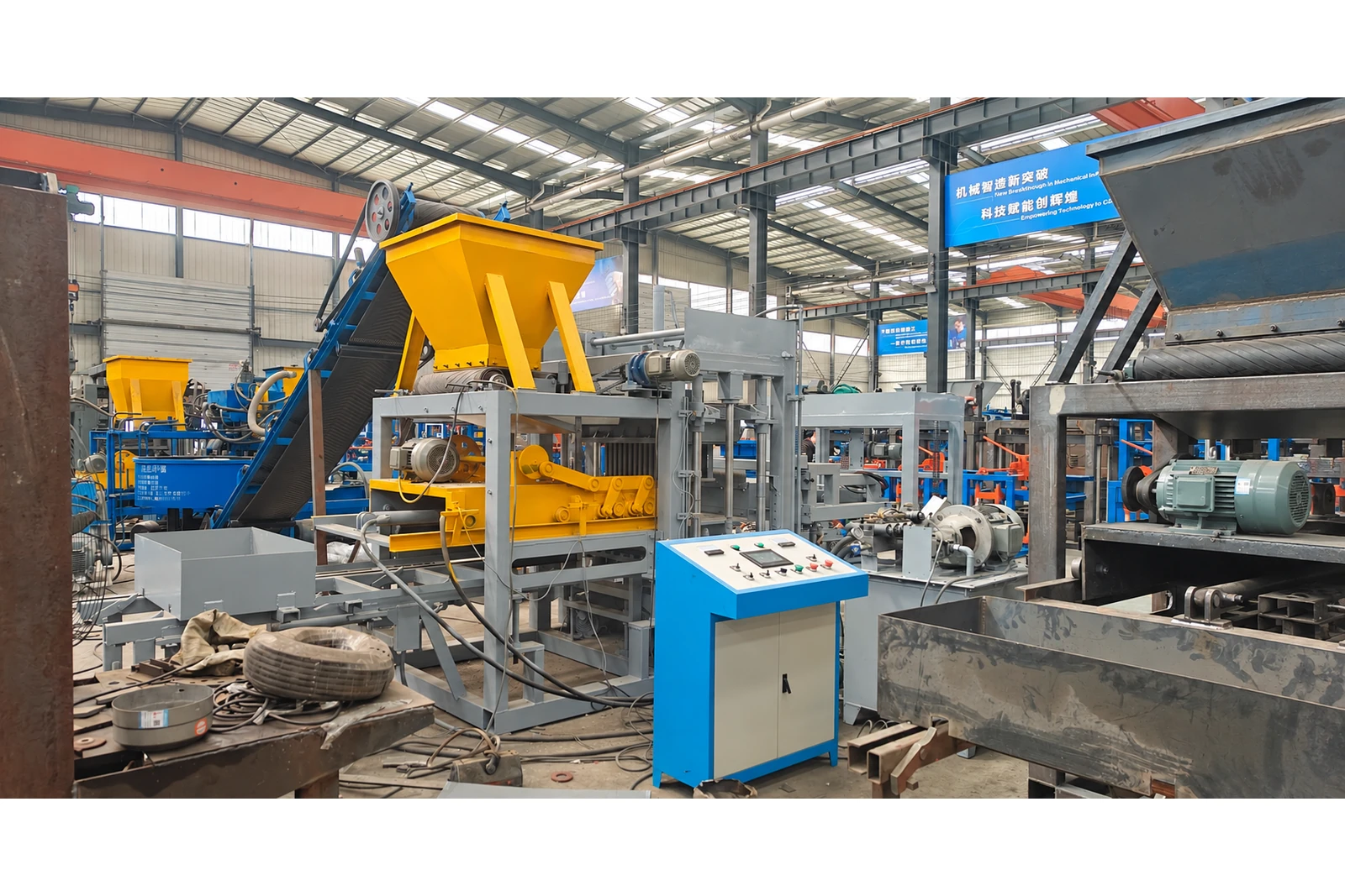 QT4-15 automatic concrete block making machine in a workshop, hopper control panel.