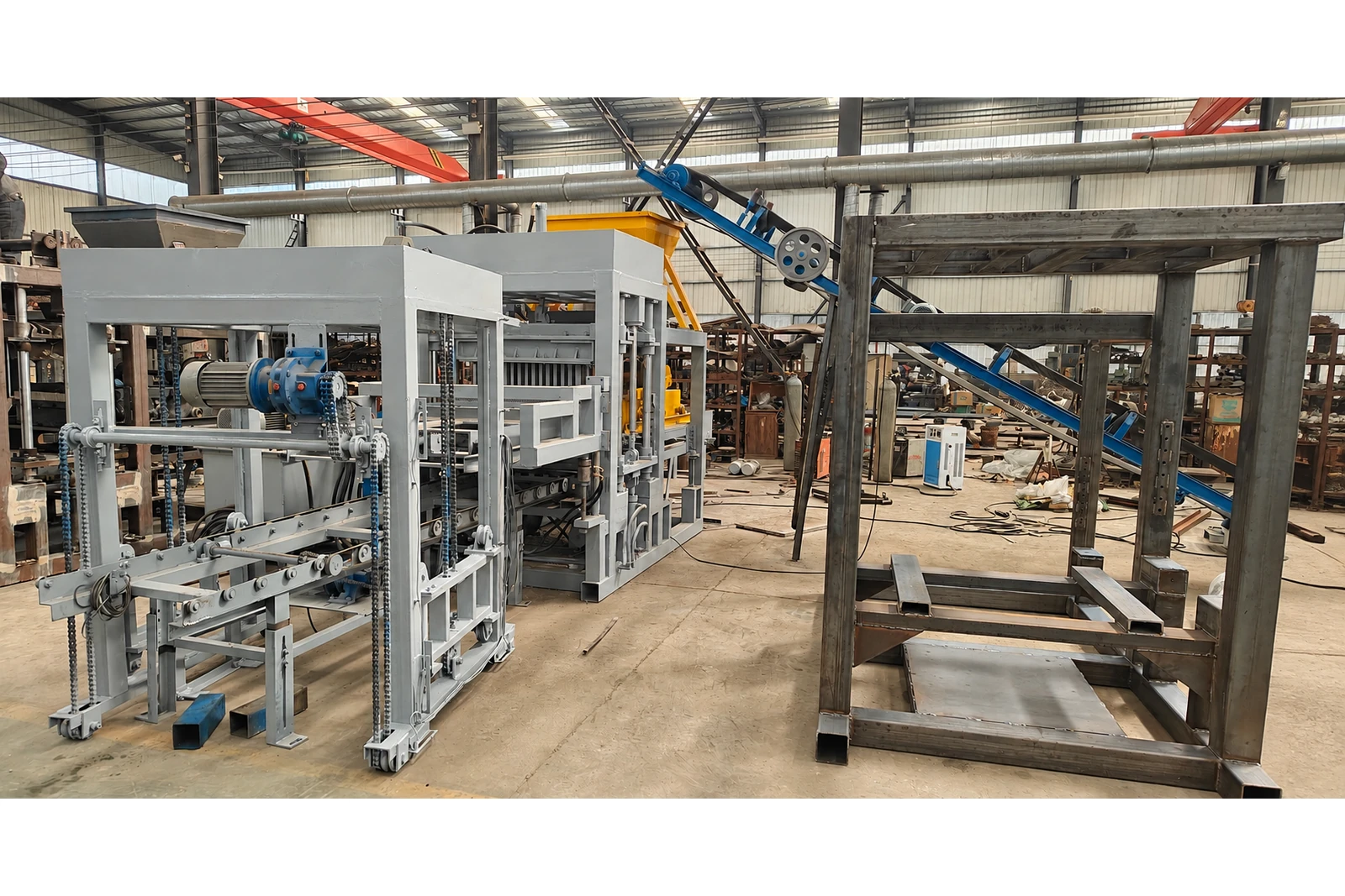 QT4-15 automatic concrete block making machine in a workshop, opposite angle.
